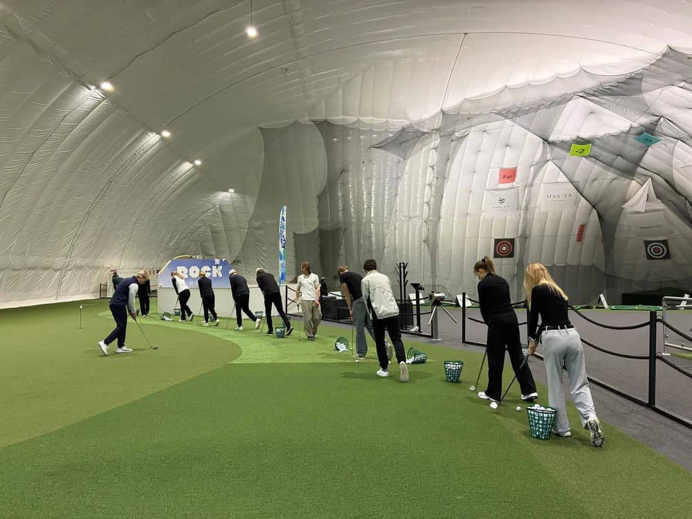 Green Card course players hitting balls from the mats in the dome
