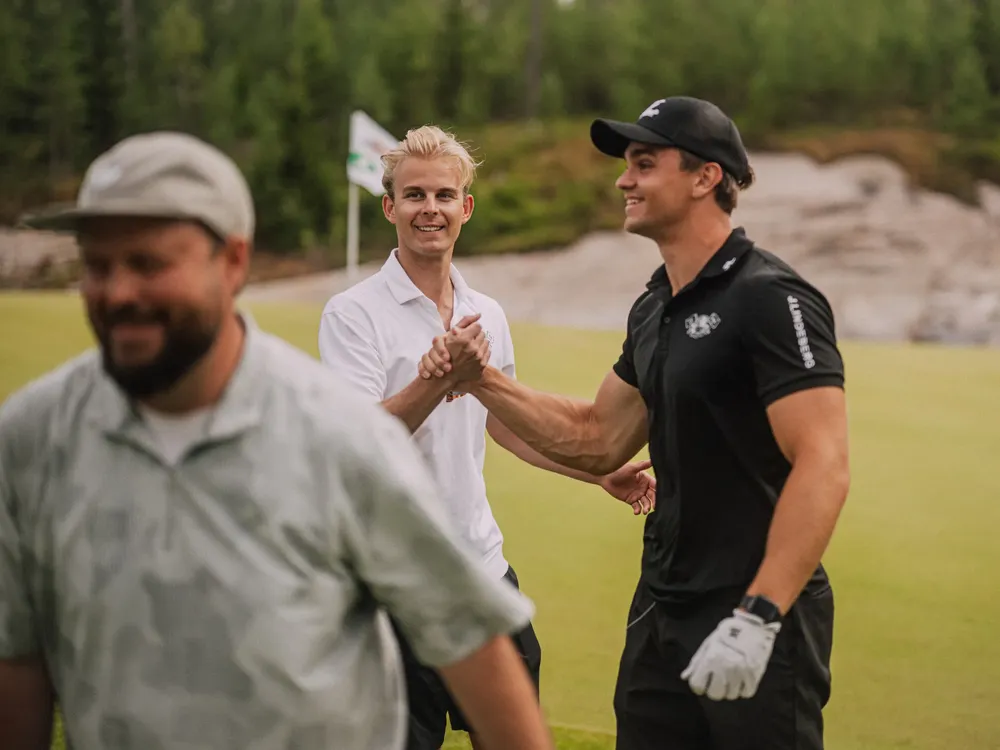 Two players shaking hands on the green after the Red Bull Shootout
