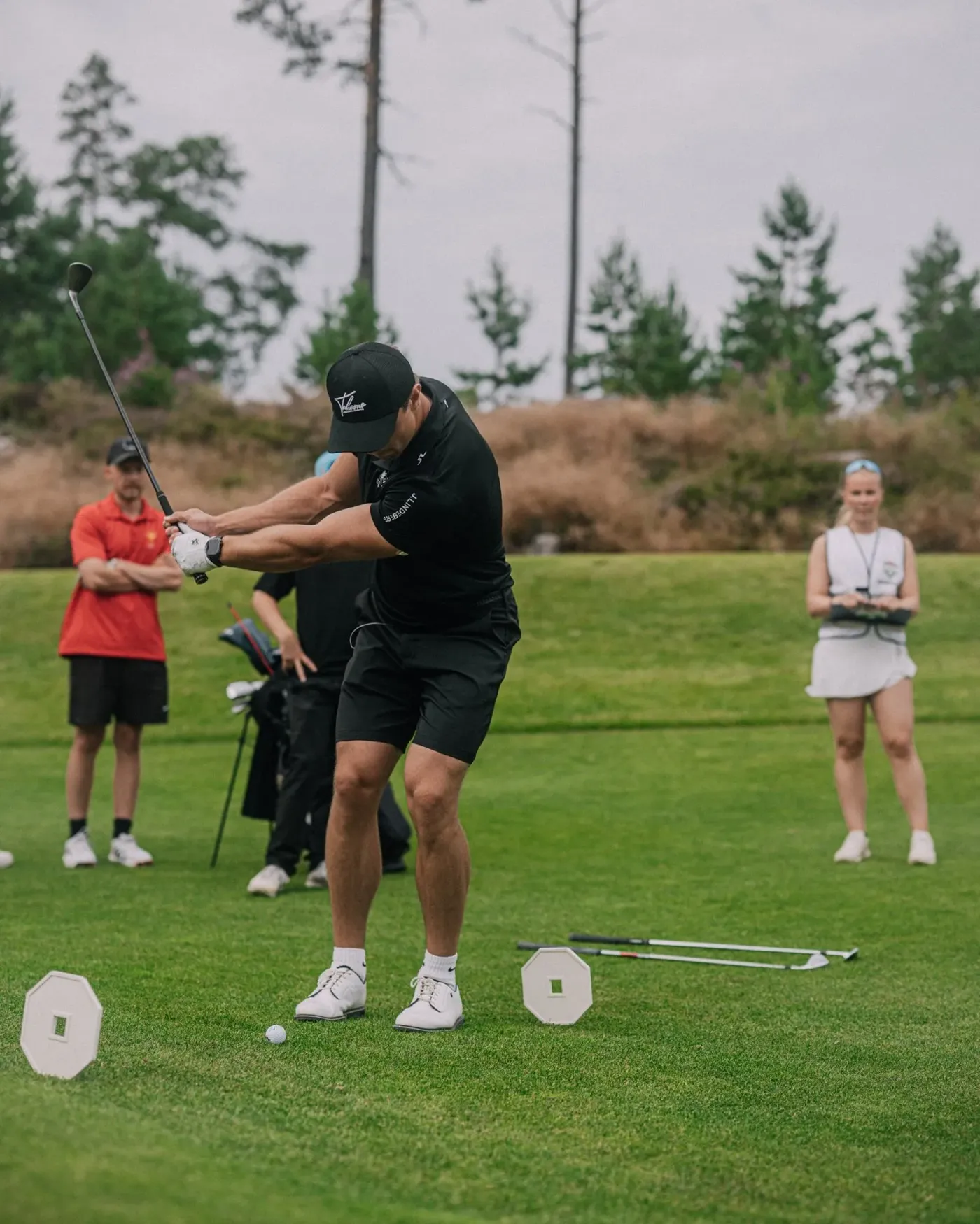 A member mid-swing while others watch